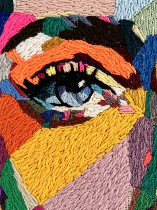 Wise combineert grof jute met verfijnd borduurwerk. Open plekken en ruwe structuren maken zichtbaar dat wijsheid ook schuilt in wat ongezegd blijft.